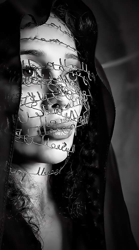 autoportrait en noir et blanc de l'artiste Zohra Hassani avec des barbelés de calligraphie arabe sur le visage